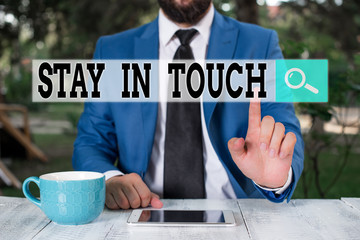 Wall Mural - Text sign showing Stay In Touch. Business photo text Keep Connected thru Phone Letters Visit Email Social Media Businessman with pointing finger in front of him