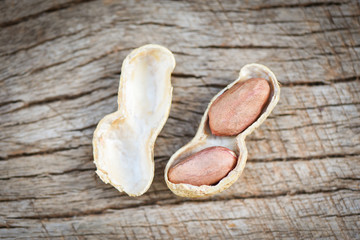 Wall Mural - Roasted peanuts on a wooden background - Shell peanut in shells for food or snack