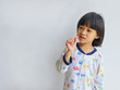 © Thachakrit - Little boy brushing his teeth copyspace on gray background