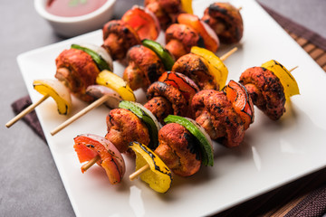 Wall Mural - Barbecue or tandoori Mushroom Tikka, served in a plate with green chutney and ketchup. selective focus