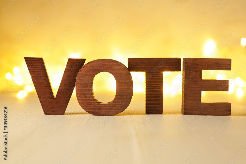 Text VOTE on table against blurred lights