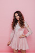 © dmitriisimakov - Portrait of a beautiful fashionable woman with hair curls in a pink dress