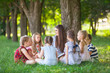 © Andrey - children hold a lesson with the teacher in the park on a green lawn.