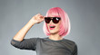 © Syda Productions - style, fashion and people concept - happy young woman in pink wig and black sunglasses over grey background