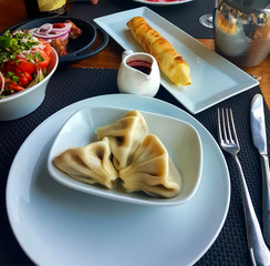 National Georgian cuisine. Hot meat khinkali with spices. Khachapuri with grilled cheese.