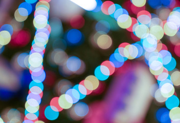 Wall Mural - Electric multi-colored garlands. Light colored spots. Festive background, blurred image.
