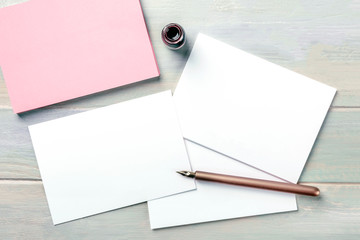 Wall Mural - Stationery mock-up with an ink bottle and a nib pen. Blank greeting cards or invitations, shot from the top