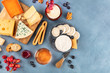 Cheese platter, a flat lay overhead shot. Blue cheese, red Leicester, Emmental, goat cheese, Brie and others with wine, fruits, nuts and almonds, with a place for text