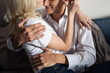 © LIGHTFIELD STUDIOS - Cropped view of blonde girl hugging smiling man on sofa