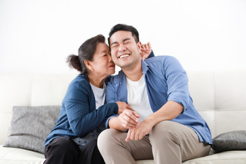 Wall Mural - Asian senior mother in blue shirt  kiss her son happy and smile face in living room