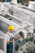 © JustLife - Man with helmet working in factory.