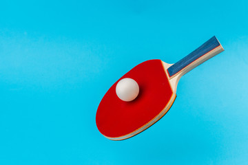 Wall Mural - Red ping pong racket on a blue background