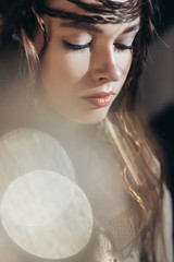 Wall Mural - tender boho woman with braids in hairstyle posing on grey with lens flares