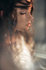 Wall Mural - beautiful boho girl with braids in hairstyle posing on grey with lens flares