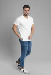 Poster - Young man in stylish jeans on grey background