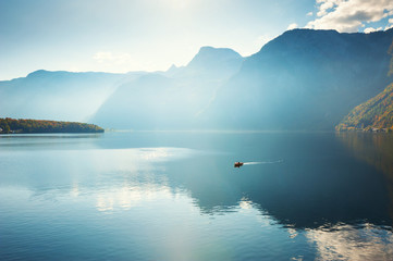 Wall Mural - Boat floating on the Hallstatter lake in Alps mountains, Austria. Beautiful autumn landscape