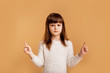 © Marharyta Hanhalo - Difficult choice, little caucasian child girl showing tho variants to choose, dilemma gesture, choose opinion, over orange background.