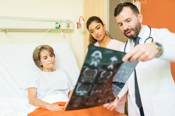 Doctors Showing Xray To Patient At Hospital