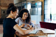 © Westend61 - Two young businesswomen working together at conference table in loft office
