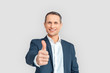 © Viktoriia - Freestyle. Mature businessman standing isolated on white thumb up smiling happy