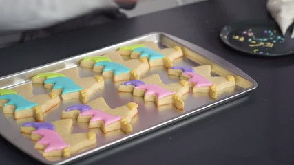 Sticker - Decorating unicorn sugar cookies with multi-color royal icing.