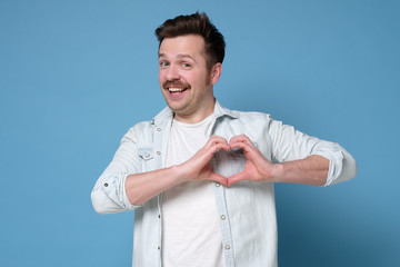 Sticker - Smiling young boy making heart gesture on his chest. Valentine day concept.