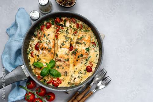 Fotografía Delicious tuscan cream salmon with spinach in a black pan