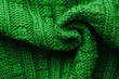 Knitted Sweater Background Twisted into a Spiral. Green mottled pattern. Facial surface. Copy space