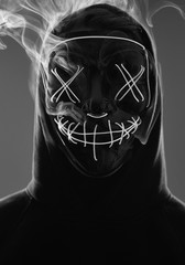 Wall Mural - Anonymous man hiding his face behind neon mask in a colored smoke