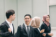 © amirul syaidi - young and confident business people walking together in a modern office corridor