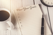 New Year's Goals List Written On Notebook With Alarm Clock, Pen, Coffee