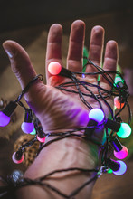 Hand With Colored Christmas Garland.