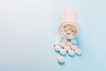 White pills on a pastel blue background. Flat lay, top view, overhead, mockup, template, copy space. Pharmacy and medical concept