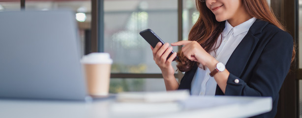 closeup image of a businesswoman using mobile phone in office