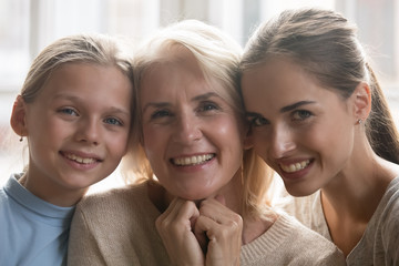 Wall Mural - Portrait of three generations of women posing at home