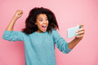 Photo of grimacing crazy excited overjoyed woman screaming in having completed level in game isolated pink pastel color background