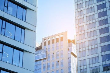 Sun rays light effects on urban buildings. Modern office building detail, glass surface with sunlight. Business background. 