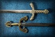 Two hilt of knightly swords close-up on a dark blue background. View from above
