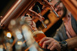 © chika_milan - Close up of handsome caucasian bearded bartender standing in bar and pouring beer from tap.