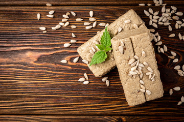 Wall Mural - Sunflower halva on dark wooden background.