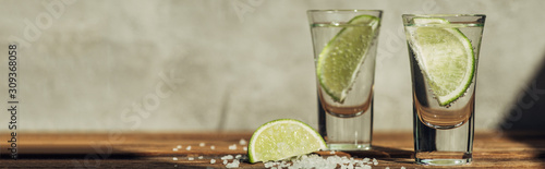 Fotomural fresh tequila with lime and salt on wooden surface in sunlight, panoramic shot