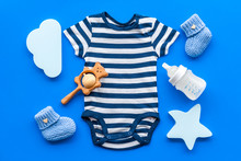 Blue Bodysuit For Baby Boy Near Children's Accessories On Blue Background Top-down