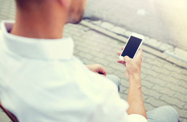 Wall Mural - technology, communication and people concept - close up of man texting message on smartphone in city