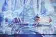 © peshkova - Financial forex graph drawn over hands taking notes background. Concept of research. Double exposure