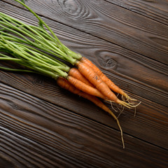 Wall Mural - Top view at Fresh organic carrots on kitchen wooden rustic table