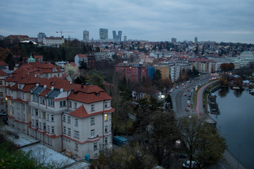 Wall Mural -  Winter panorama from Vysehrad Castle to the evening city of Prague, residential areas, the Vltava River, moorings with boats and boats and city transport.