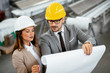© JustLife - Close up of colleagues in factory. Architects working on project.