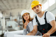 © JustLife - Close up of colleagues working on project in factory.