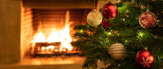 Wall Mural - Christmas tree close up on burning fireplace background