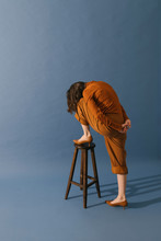 Model With Brown Outfit On Blue Background